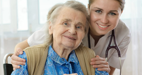 Nurse hugging an older lady from behind